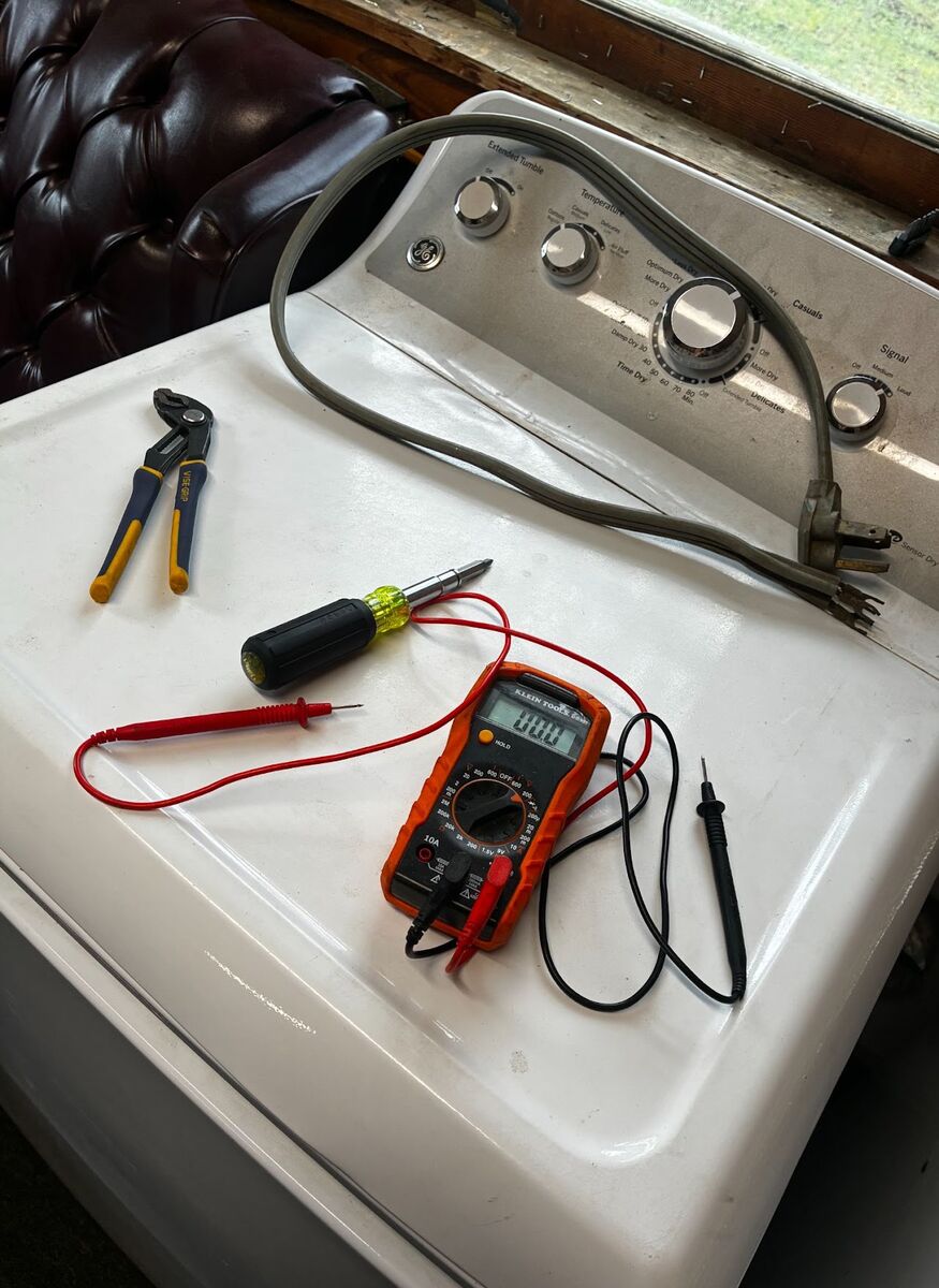 Testing a dryer's control panel for continuity before diagnosing further.