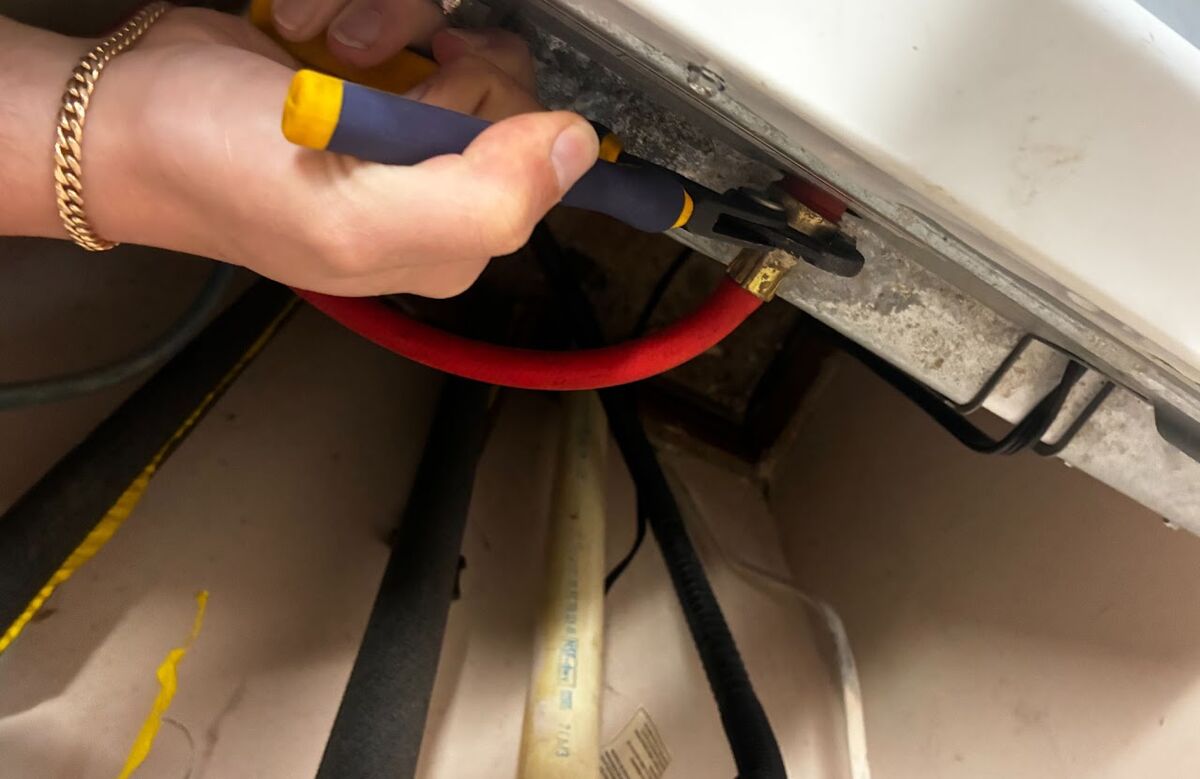 Checking a water line connection during a service call.