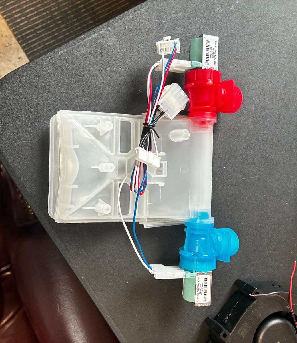 A dual water inlet valve assembly pulled from a washer for testing.